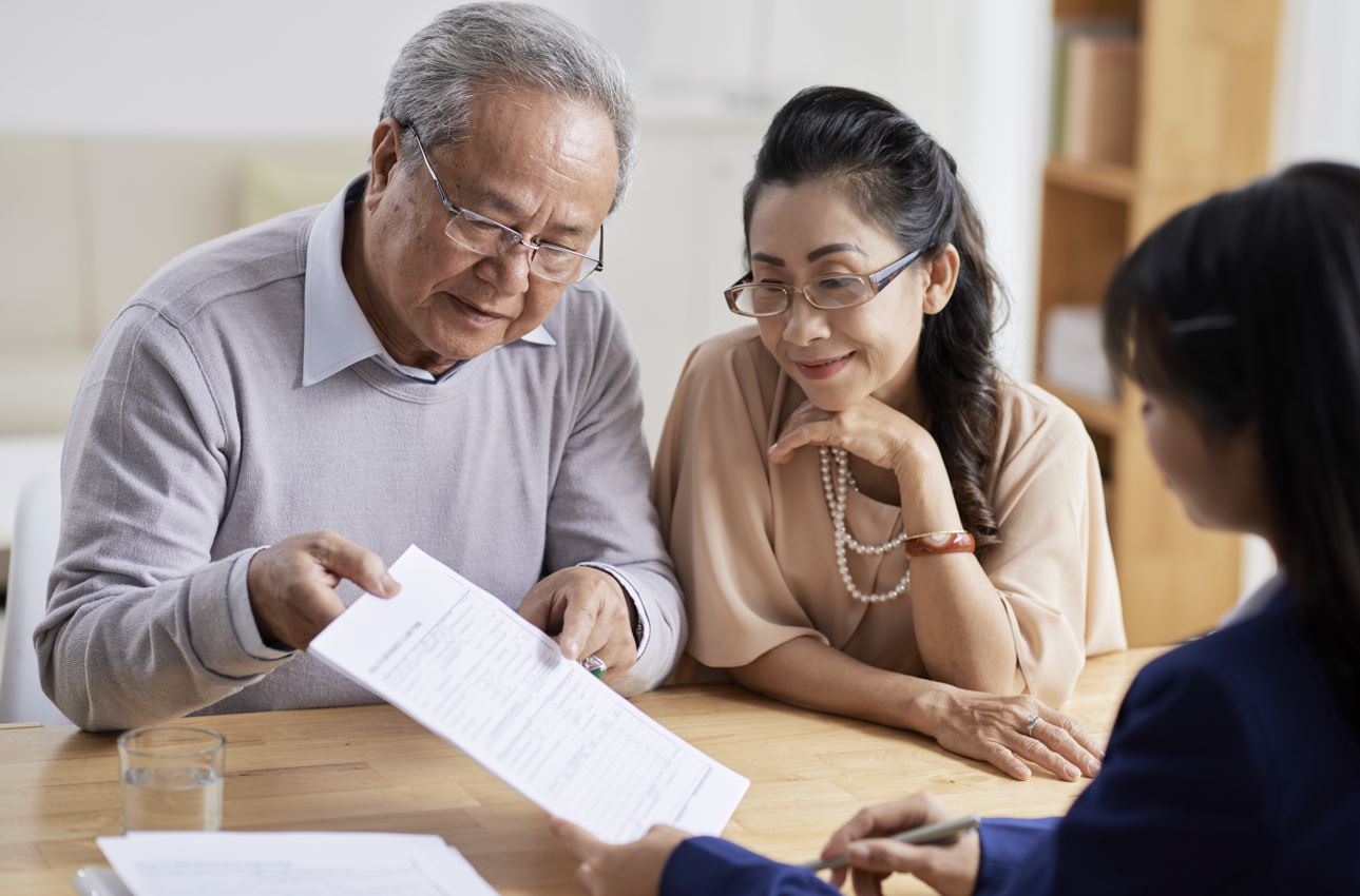Older couple looking at a paper in the living room