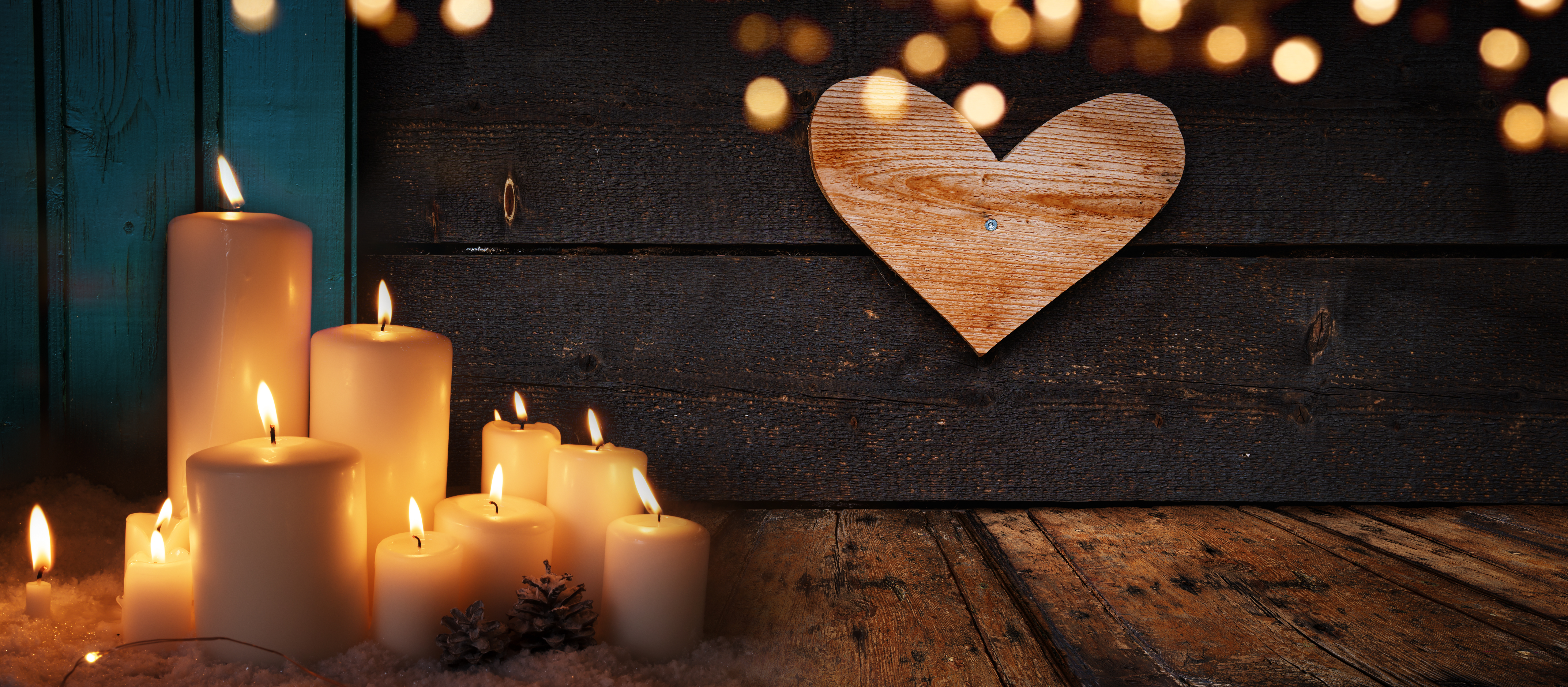 Burning candle lights on dark old wood stock photo